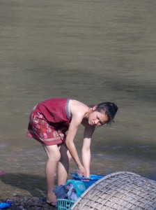 Wassen in de rivier, zowel zichzelf als de kleren / Washing in the river, herself as well as clothes